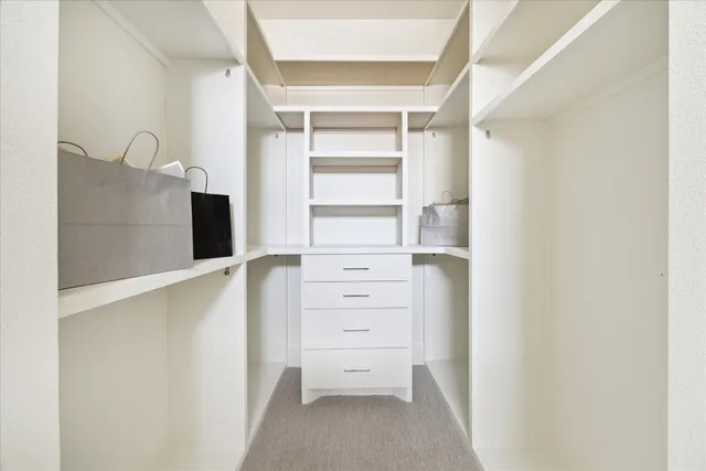 a view of walk in closet with empty racks