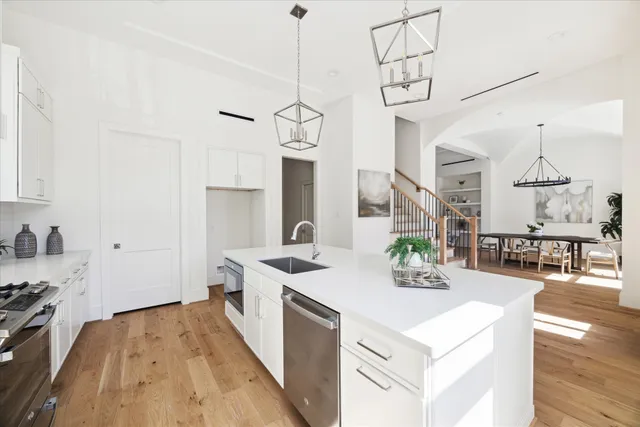 a view of a kitchen with kitchen island a sink wooden floor and living room view