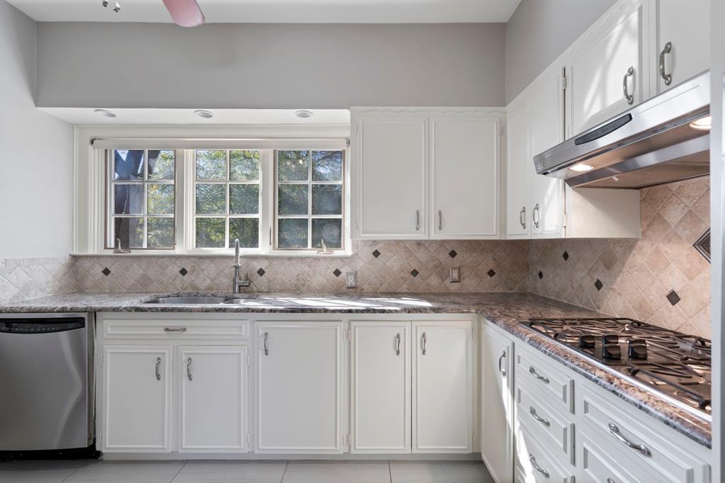 8530 Jourdan Way Dallas, TX 75225 - Photo 13 of 39 Kitchen with stainless steel appliances, white cabinetry, light tile patterned floors, and dark stone counters