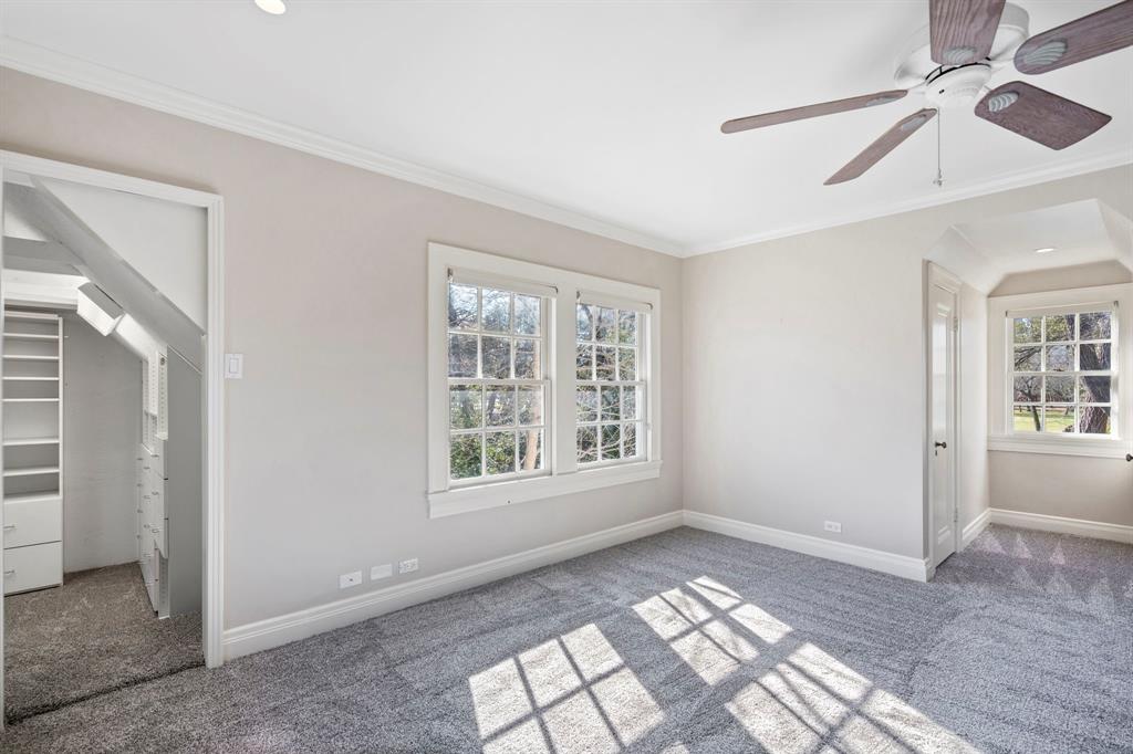 8530 Jourdan Way Dallas, TX 75225 - Photo 20 of 39 Unfurnished bedroom featuring carpet, ornamental molding, a ceiling fan, and a walk in closet