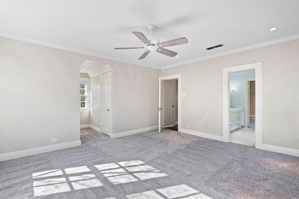 8530 Jourdan Way Dallas, TX 75225 - Photo 21 of 39 Unfurnished bedroom with light colored carpet, ornamental molding, arched walkways, a ceiling fan, and ensuite bath