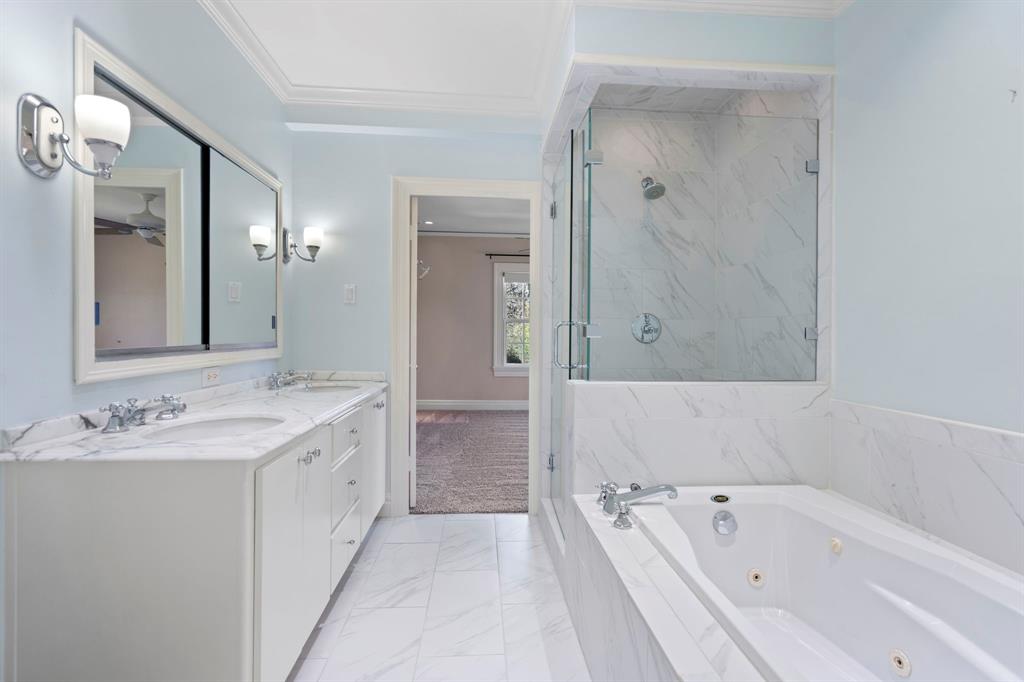 8530 Jourdan Way Dallas, TX 75225 - Photo 22 of 39 Full bath with double vanity, light marble finish flooring, a marble finish shower, a whirlpool tub, and ornamental molding