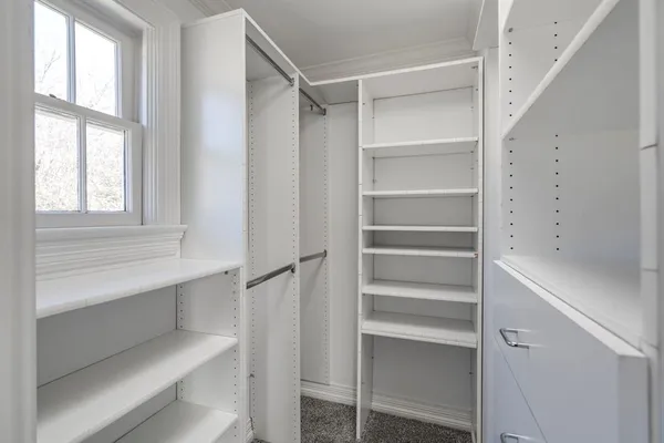 a view of walk in closet with empty racks