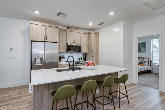 a kitchen with stainless steel appliances a white table and chairs in it