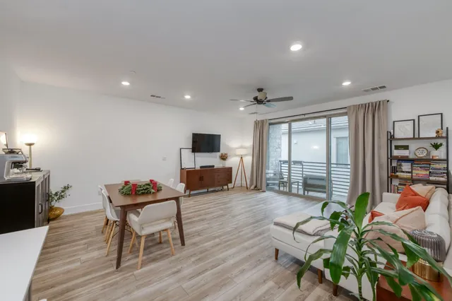 a view of a dining room with furniture a chandelier and wooden floor