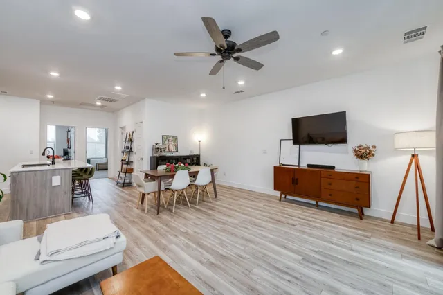 a kitchen with granite countertop kitchen island stainless steel appliances a dining table and chairs