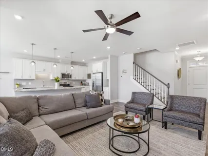 a living room with furniture a rug and kitchen view