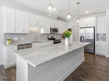 a kitchen with stainless steel appliances granite countertop a sink refrigerator and microwave