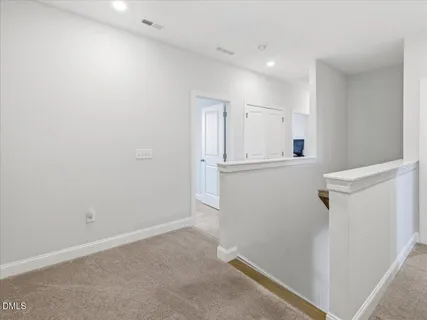 a view of an empty room with closet and a window