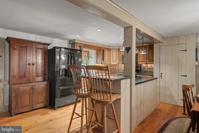 a kitchen with stainless steel appliances a refrigerator and wooden floor