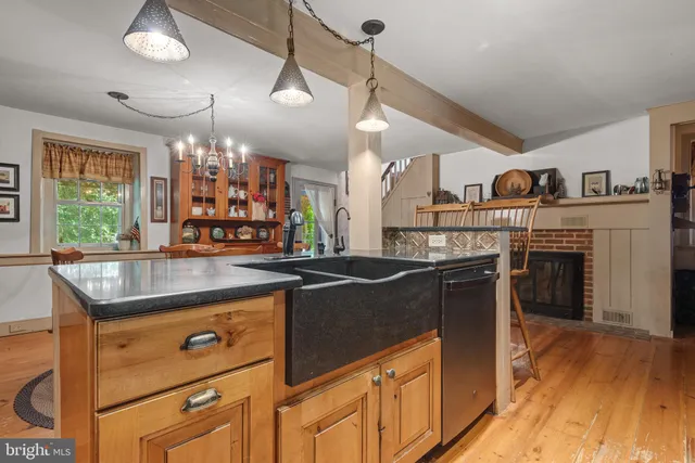 a kitchen with kitchen island granite countertop a stove and a wooden floors