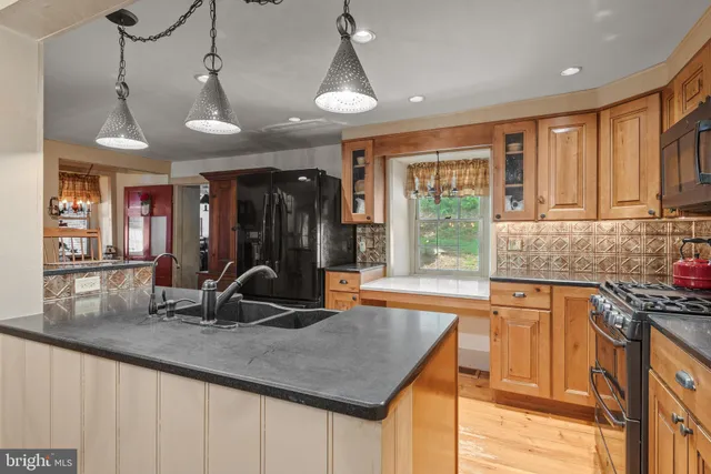 a kitchen with stainless steel appliances granite countertop a sink a stove and a refrigerator