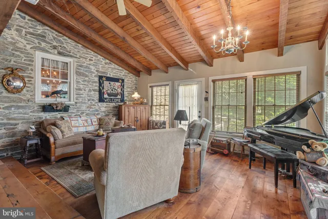 a living room with furniture floor to ceiling window and wooden floor