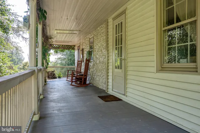 a view of a porch with wooden floor and furniture
