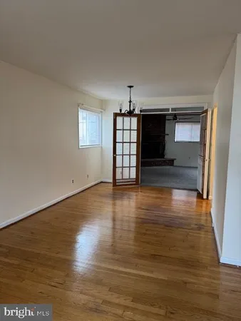 a view of a livingroom with wooden floor a flat screen tv and kitchen view