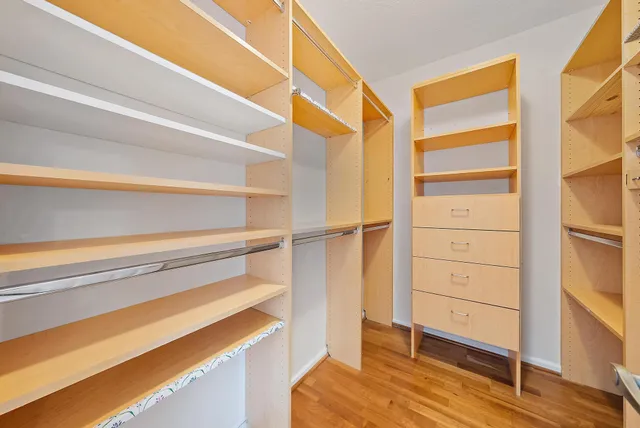 a view of walk in closet with clothes and shoes