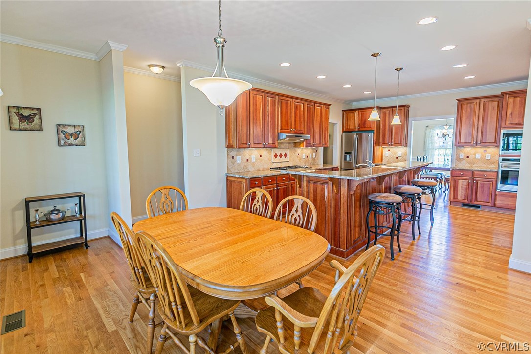 10180 Scots Landing Road Mechanicsville, VA 23116 - Photo 22 of 50 a view of a dining room and livingroom with furniture wooden floor a chandelier