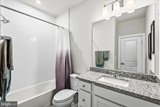 a bedroom with a bed and dresser with mirror