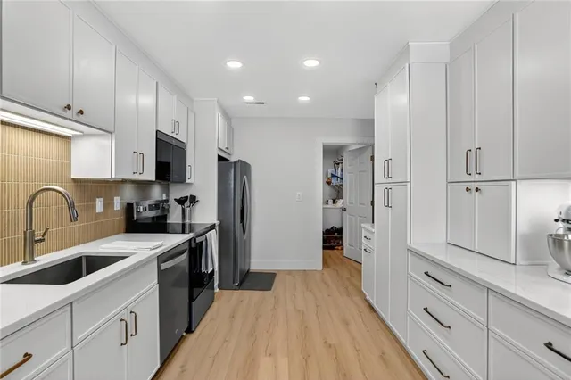 a kitchen with white cabinets and stainless steel appliances