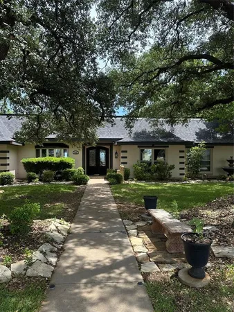 a front view of a house with a yard and a garden