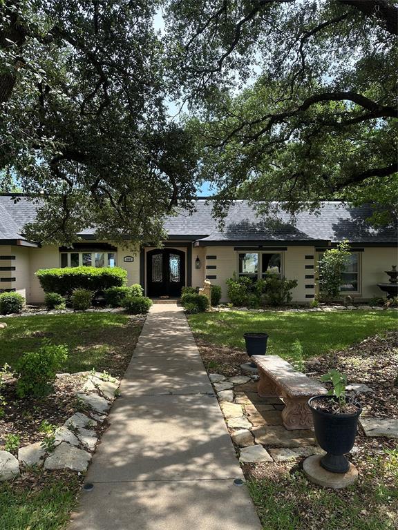 a front view of a house with a yard and a garden