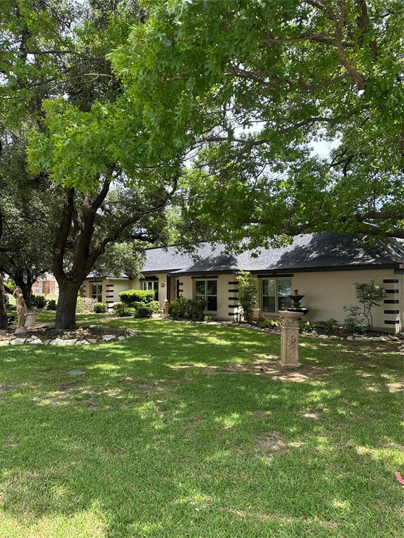 505 High Road Coleman, TX 76834 - Photo 2 of 38 a front view of a house with a garden and trees