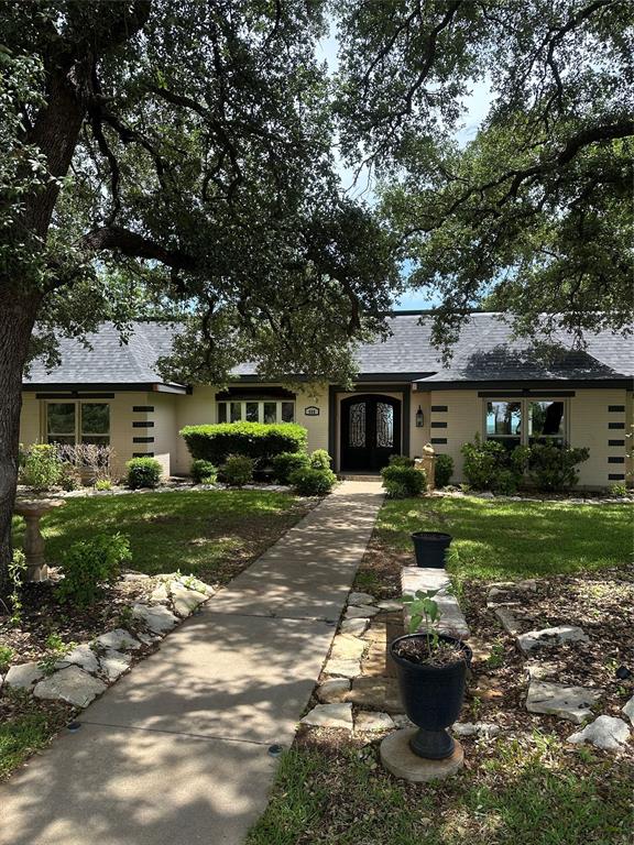 505 High Road Coleman, TX 76834 - Photo 3 of 38 a front view of a house with a yard fire pit and large tree