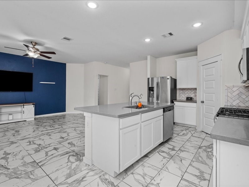 9203 Waldrick Trace Drive Rosharon, TX 77583 - Photo 19 of 35 a kitchen with stainless steel appliances a sink a stove a refrigerator cabinets and living room view