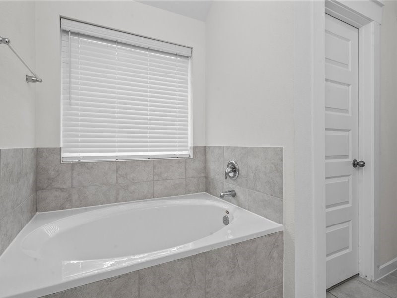 9203 Waldrick Trace Drive Rosharon, TX 77583 - Photo 27 of 35 a bath tub sitting next to a white sink and vanity