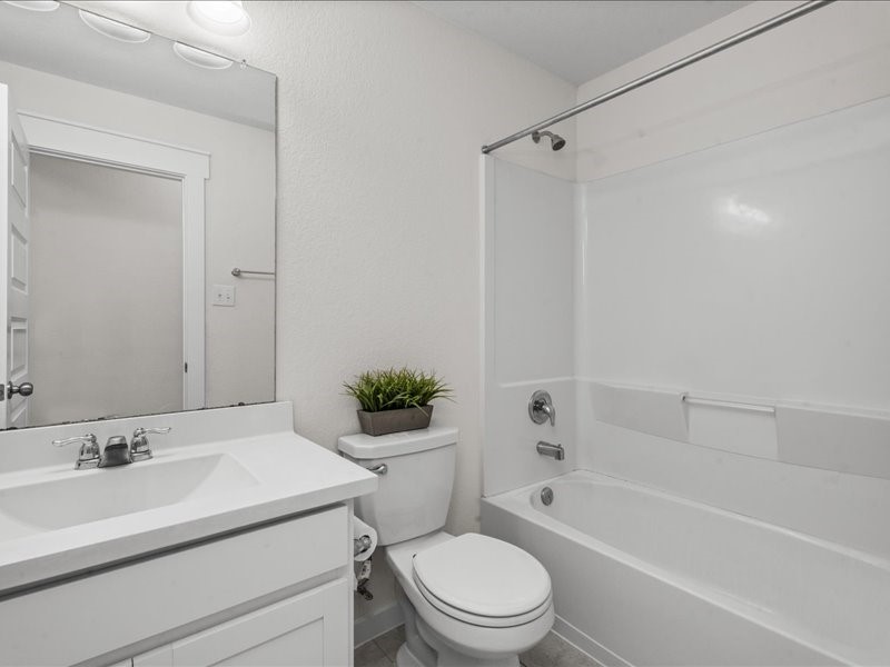 9203 Waldrick Trace Drive Rosharon, TX 77583 - Photo 9 of 35 a bathroom with a granite countertop toilet a sink and a bathtub