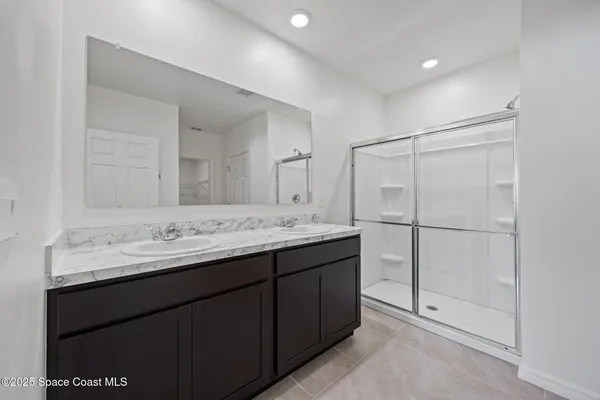 a bathroom with a granite countertop sink a mirror and a shower