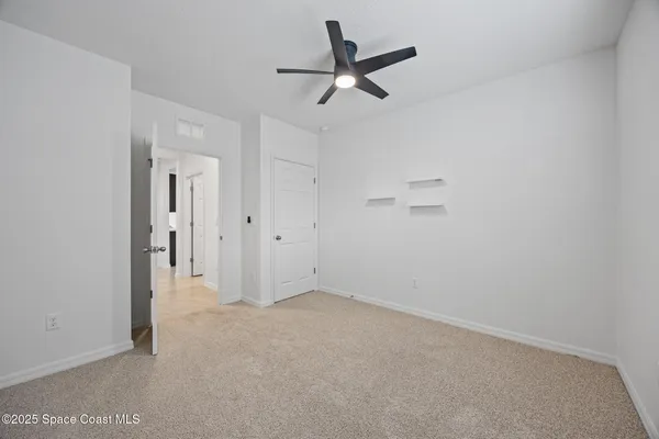 an empty room with a window and a fan