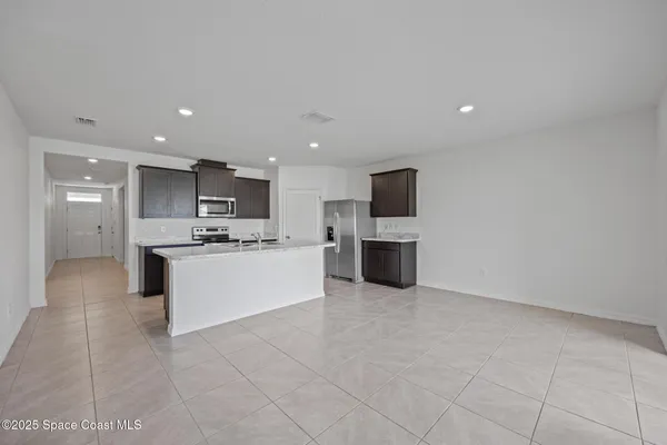 a large kitchen with kitchen island a sink a counter top space stainless steel appliances and cabinets