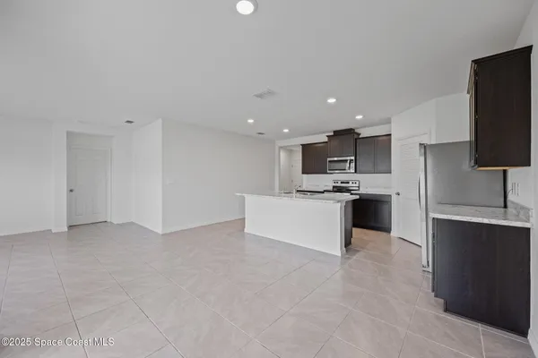 a large kitchen with kitchen island a sink a counter top space and stainless steel appliances