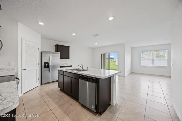 a kitchen with stainless steel appliances granite countertop a refrigerator and a stove top oven