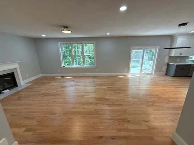 a view of an empty room with a window and fireplace