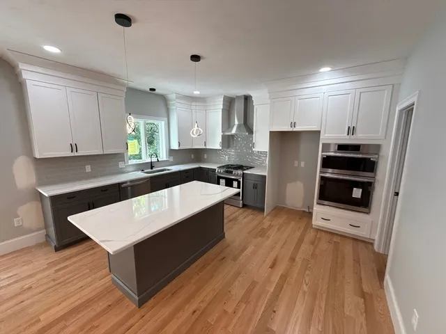 a kitchen with stainless steel appliances a refrigerator and a stove top oven