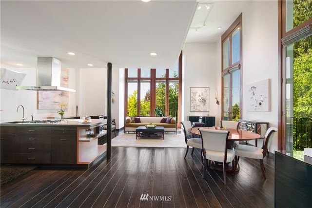 a view of a kitchen with kitchen island stainless steel appliances a dining table and chairs