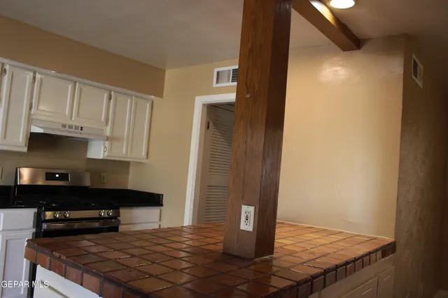 a kitchen with stove and cabinets