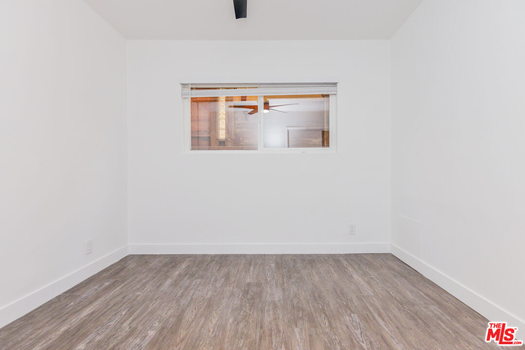2107 Pullman Lane, Unit A Redondo Beach, CA 90278 - Photo 20 of 42 a view of an empty room with wooden floor and a window