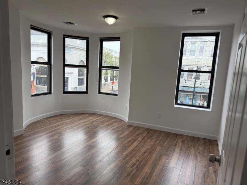 182 Ferry Street, Unit 2F Newark, NJ 07105 - Photo 12 of 14 an empty room with wooden floor and windows