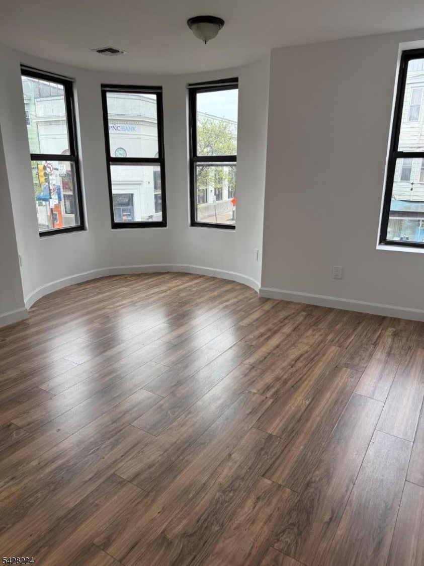 182 Ferry Street, Unit 2F Newark, NJ 07105 - Photo 14 of 14 a view of an empty room with wooden floor and windows
