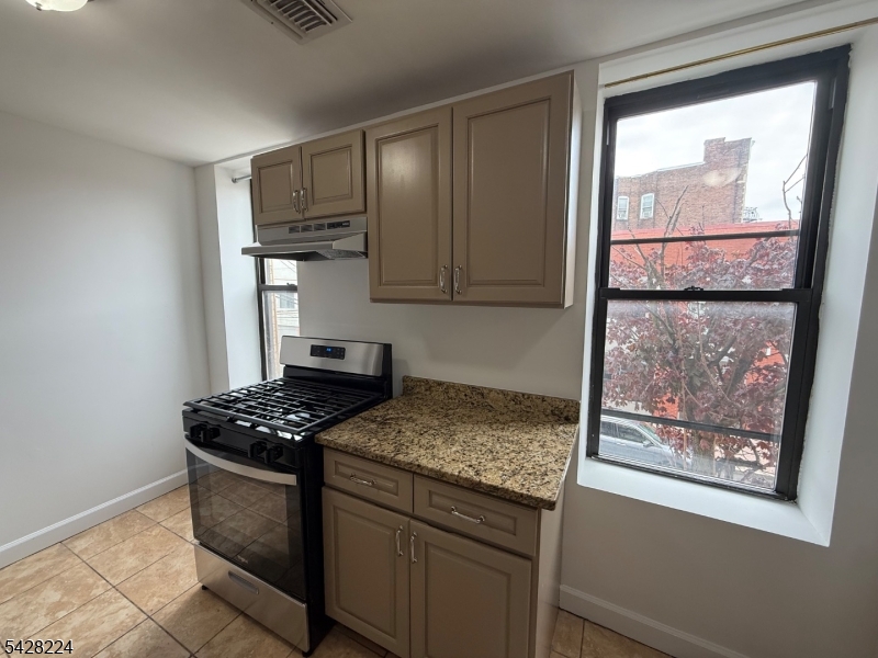 182 Ferry Street, Unit 2F Newark, NJ 07105 - Photo 5 of 14 a kitchen with stainless steel appliances granite countertop a stove a sink and a microwave