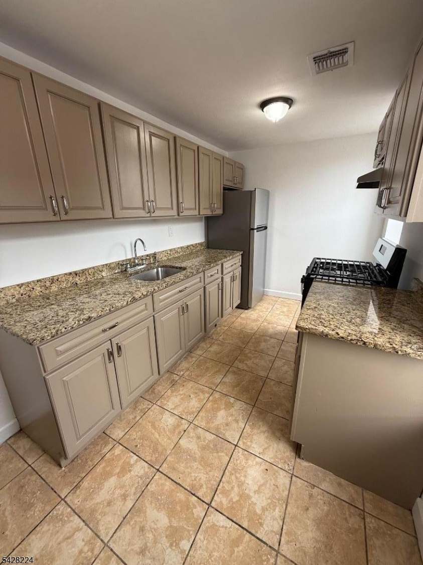 182 Ferry Street, Unit 2F Newark, NJ 07105 - Photo 6 of 14 a kitchen with granite countertop a sink stove and cabinets