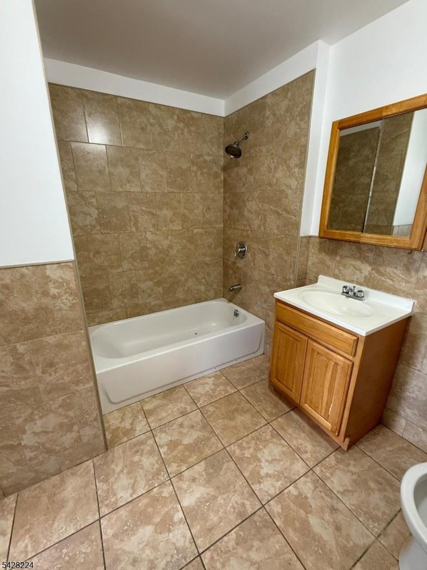 182 Ferry Street, Unit 2F Newark, NJ 07105 - Photo 9 of 14 a bathroom with a tub a sink and a mirror