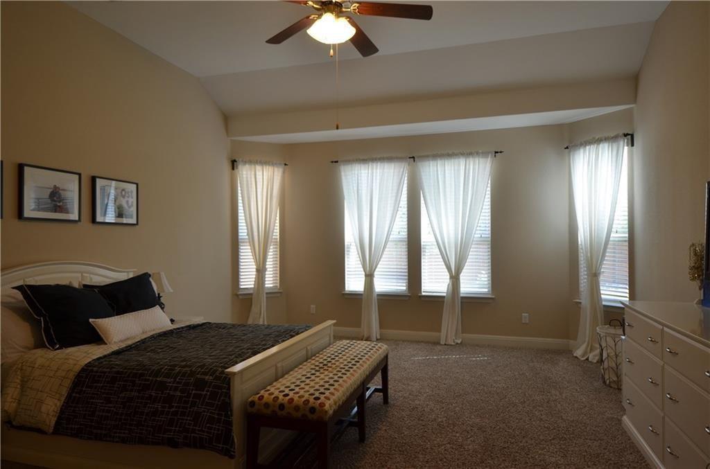 5629 Rio Chama Cove Austin, TX 78738 - Photo 12 of 34 An airy primary bedroom showcases vaulted ceilings and ample natural light from multiple windows.