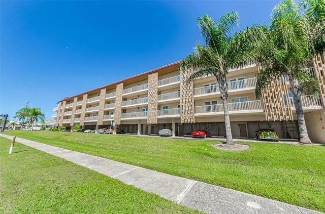 a view of a swimming pool with lawn chairs under an umbrella