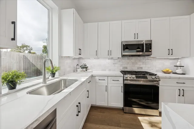 a kitchen with appliances a sink and cabinets