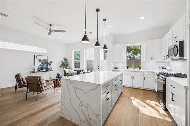 a large kitchen with stainless steel appliances kitchen island granite countertop a sink a stove a dining table and chairs