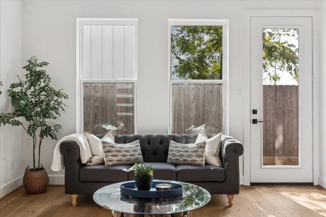 a living room with furniture potted plant and a large window